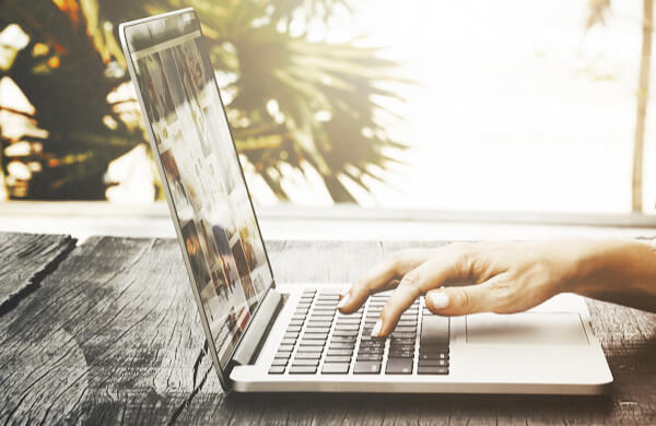 Person Using Laptop Near Ocean